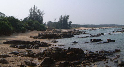 A view across rocky shoals and a narrow beach