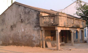 A house with a verandah and an impossibly low second floor